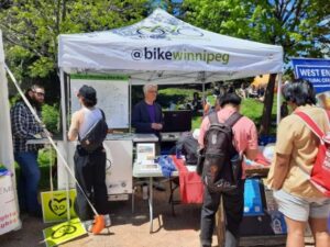 Photo of Bike Winnipeg tent and display trailer with the public at Pride Winnipeg 2022