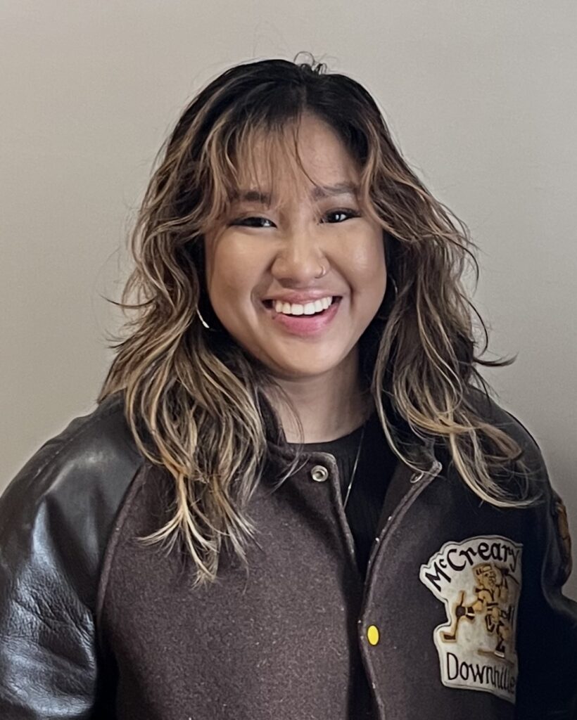 smiling woman with gently curled long dark hair and highlights