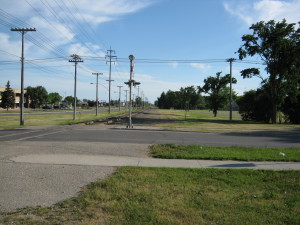 Looking south towards Notre Dame along the western right of way for the BNSF rail line from the northwest corner of its intersection with Alexander. Pascoe Park is seen to the right (west). There is ample room for a rail with trail pathway along this stretch